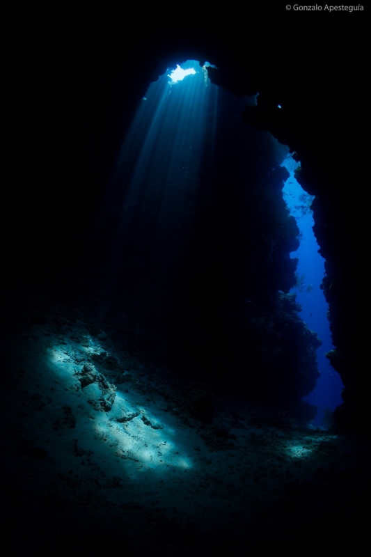 Sunlight through an opening in the reef and the entrance to a cave
